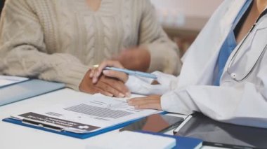 Hastanedeki hastayla birlikte doktor panoya yazı yazıyor..