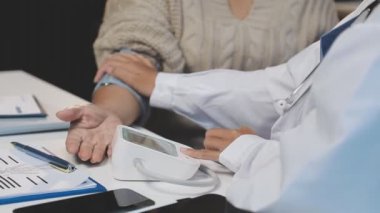 Hastanedeki hastanın tansiyonunu ölçen doktor.