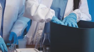 Test tüpü tutan koruyucu eldivenli laboratuvar çalışanı.