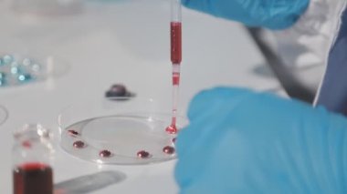 Kırmızı sıvı ile laboratuvar asistanı