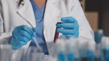 Kimyasal test tüpüyle çalışan bilim adamının yakın görüntüsü