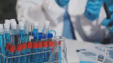 Laboratuvar asistanı ellerinde test tüpleri tutuyor.