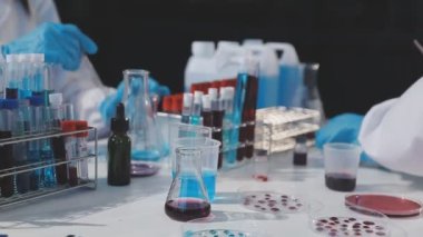 Laboratuvar asistanı elinde bir kan testi tüpü tutuyor..