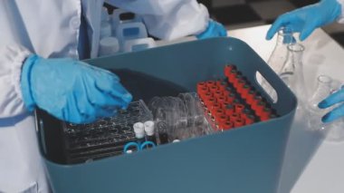 Laboratuvarda çalışan eldivenli bilim adamı.
