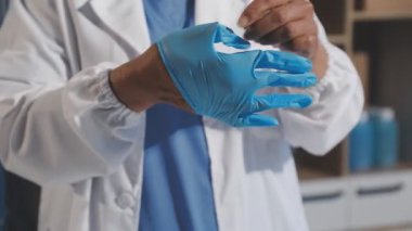 Doktor elinde tıbbi eldiven tutuyor.