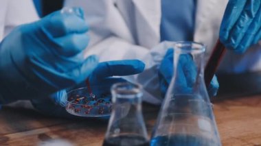 Bilim adamı elinde sıvı bir test tüpü tutuyor.