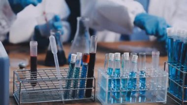 Laboratuvarda test tüpü ve arka planda mavi sıvı..