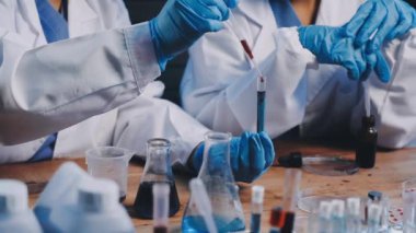 Yakın plan - bilim adamının deney tüpüyle matarayı tutuşu