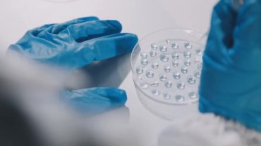 Yakın plan. Doktorun laboratuvarda elinde bir aşı tüpü tutması..