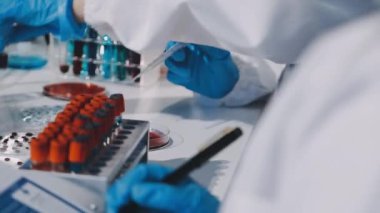 Laboratuvar asistanı. Laboratuvar tüpünde kan örneği var..