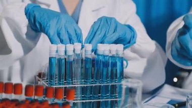 Yakın plan - bir bilim adamının elinde sıvı bir tüp tutarken