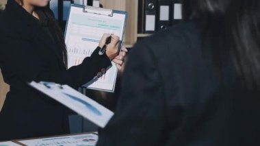 İş adamları toplantı odasında toplanıyor. Ofisteki iş adamları. İş ekibi verileri tartışıyor. Kağıt belge ile çalışan iş kadınları ve işadamları.
