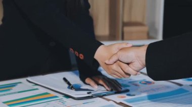 İş adamı ve iş adamı el sıkışıyor, modern ofiste buluşuyorlar..