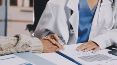 Doktor hasta elini elinde tutuyor..