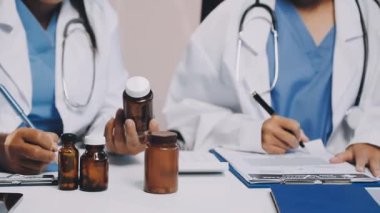 Doktor elinde şişeyle hapları tutuyor.