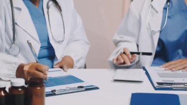 Doktor modern ofisteki masaya reçete yazıyor.