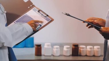 Doktor Eli 'nin elinde bir tablet tutarak hastaya tıbbi rapor göstermesini kapatın.