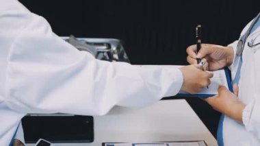 Doktor bir hastane masasında hastanın kan basıncını ölçüyor.