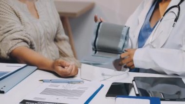 Doktor klinikteki hasta basıncını kontrol ediyor.