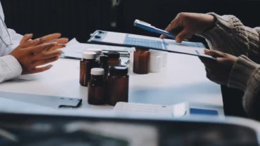 Doktor masadaki kan basıncını, sağlık hizmetlerini ve ilaçları kontrol ediyor.