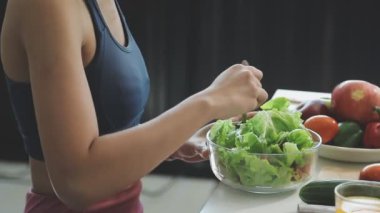 Mutfakta bir kase taze salata tutan kadın..