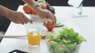 Genç bir kadın mutfakta salata pişiriyor..