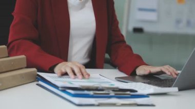 Hesap makinesi ve dizüstü bilgisayarı olan genç bir kadın