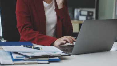 İş kadını ofiste dizüstü bilgisayarla çalışıyor..