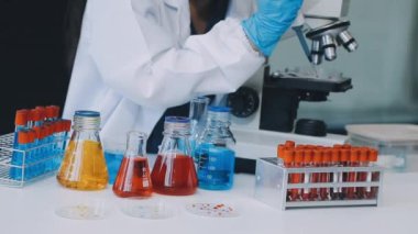 Koruyucu eldiven ve eldiven giymiş kadın doktor. Laboratuvarda kan testi, koronavirüs, covid - 19 virüsü içeren tüp tutuyor.