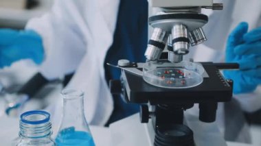 Laboratuvarda mikroskobu olan bir laboratuvar çalışanına yakın plan.