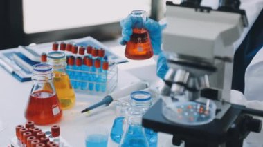 Laboratuvarda mikroskopla çalışan kadın bilim adamına yakın çekim.