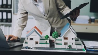 Emlakçı bir model ev tutan