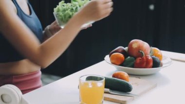 Kadın elinde taze sebze salatası tutuyor.