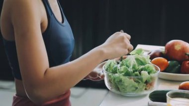 Genç bir kadın modern mutfakta salata pişiriyor. sağlıklı yaşam tarzı