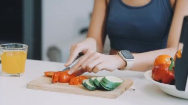 Mutfakta sebzelerle yemek pişiren kadın.