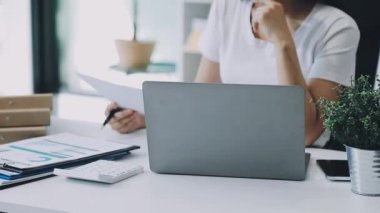 İş kadını ofiste dizüstü bilgisayar kullanıyor.