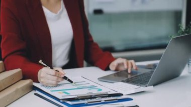 Ofiste dizüstü bilgisayarı ve tableti olan bir iş kadını..