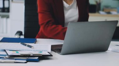 Evde dizüstü bilgisayar ve kredi kartıyla çalışan bir kadın.