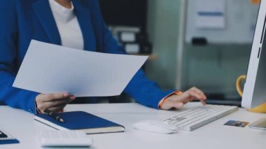 Takım elbiseli genç iş kadını kağıda yazıyor.