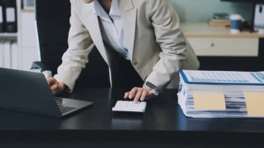 Ofiste evrakları olan genç bir kadın var..