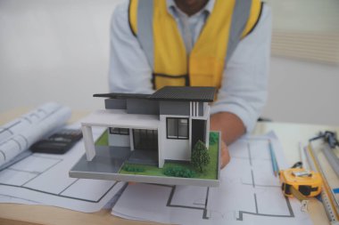 Mimarlar, mühendisler, müteahhitler ofiste planlar, teftiş mühendisleri mimari plan analizi, inşaat projesi taslağı, odaklanma, iş inşaatı konsepti ile çalışıyorlar..