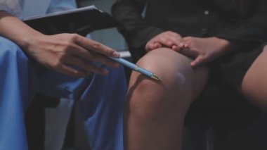 Yakın plan - hastanede dizini muayene eden kadın doktor..