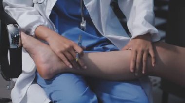 Doktor muayenehanedeki kadın hastayı muayene ediyor.