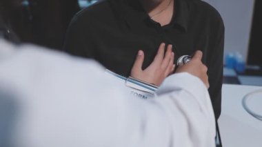 Doktor hastanın tansiyonunu ölçüyor.