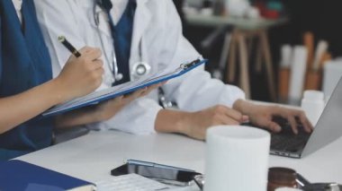 Bilgisayarla ofis masasında çalışan bir doktor.