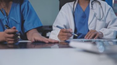 Bir grup genç doktor hastanede tıbbi planı tartışıyor..