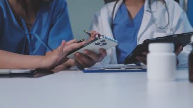 Akıllı telefonu tutan doktoru kapat ve masaya not al..