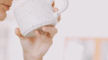 Kadın elinin kahve fincanını tutarken..