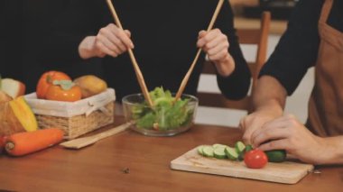 Gençler mutfakta salata pişiriyor.