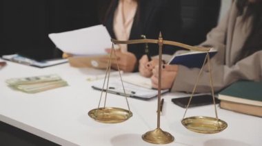 Ofis masasında terazi, hukuk kitabı ve kalemle çalışan bir avukat. Hukuk ve adalet kavramı, avukat ve avukat.